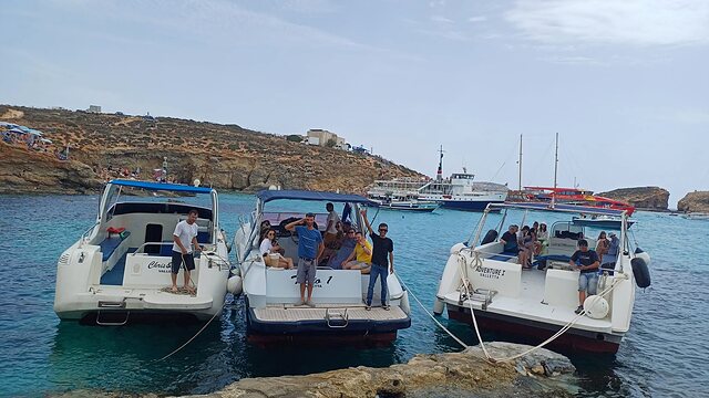 Guests waving from Adventure Cruises boats rafted at the Blue Lagoon.