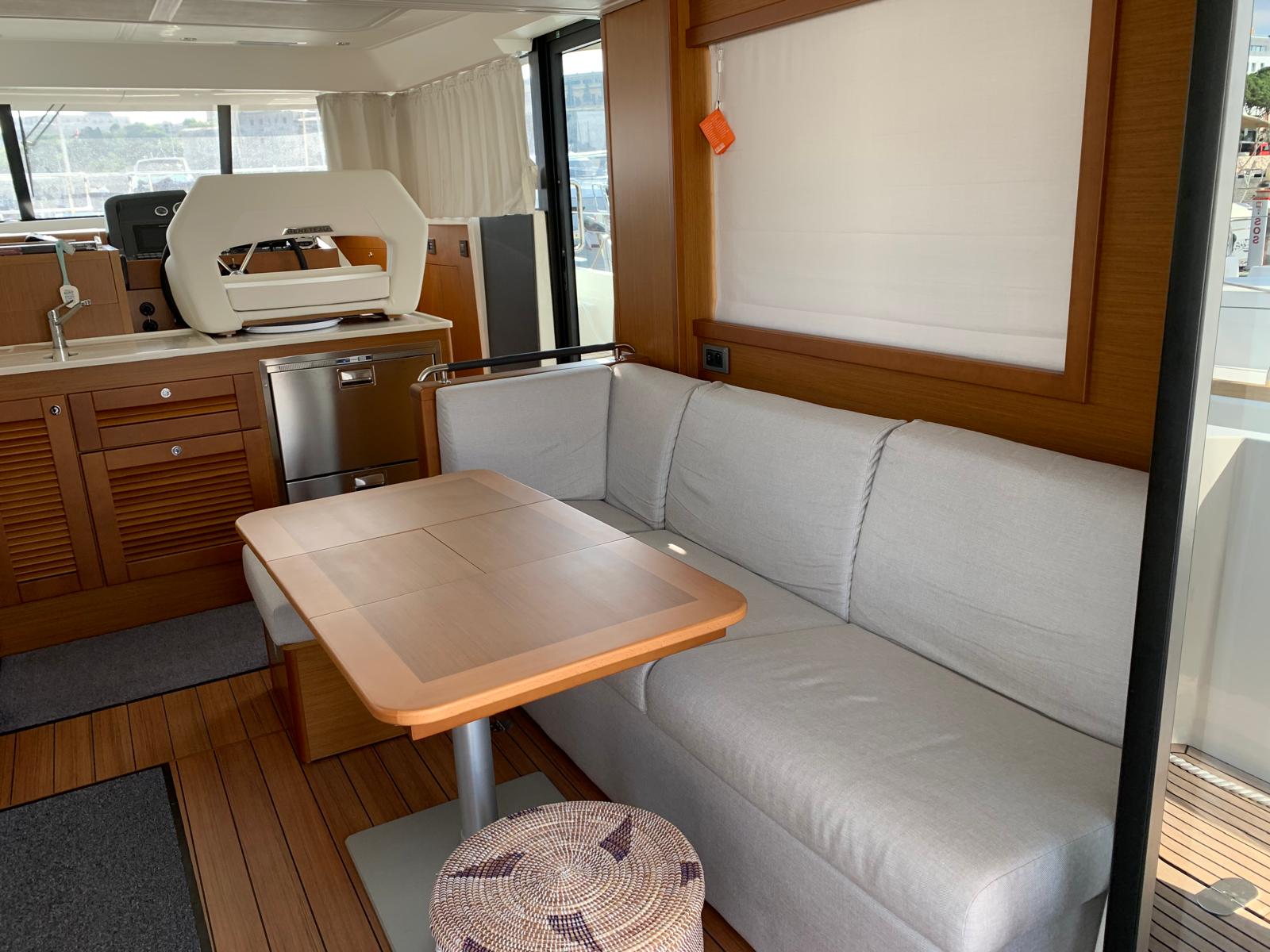 Interior saloon with grey couch and dining table
